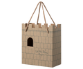 Cardboard castle toy with a rope handle on a white background