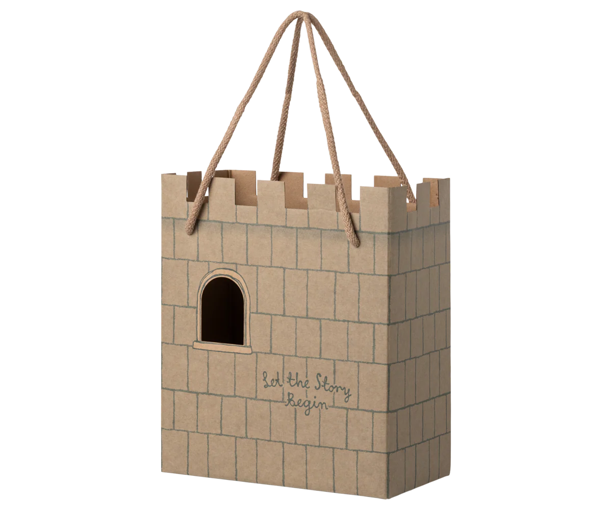 Cardboard castle toy with a rope handle on a white background