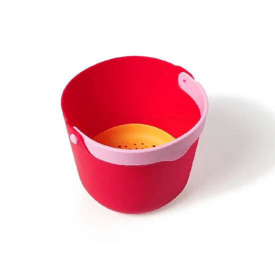 Red and pink colander with a yellow interior on a white background
